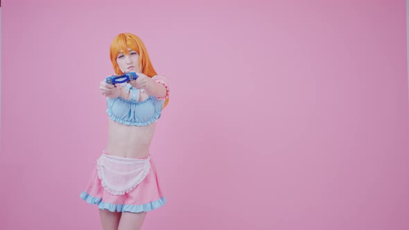 Beautiful Fit Caucasian Girl Cosplayer Tries Out Her New Game Pad Medium Long Shot Pink Background