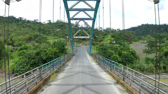 Moving backward between the metal cables of a truss bridge