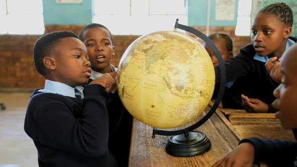Schoolkids using globe in classroom 4k