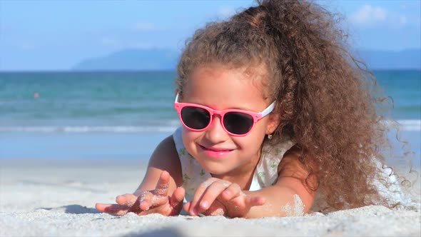 Close-Up Portrait of a Beautiful Little Girl in Pink Glasses, Cute Smiling Looking at the Camera