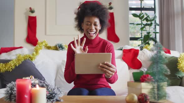 Happy african american woman wearing santa hat making video call