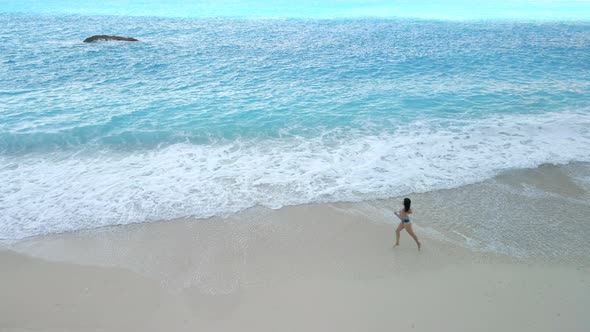 Young Sexy Woman in Swimsuit Running By Sea Beach