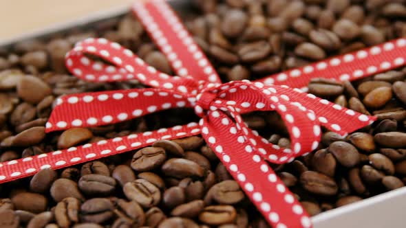 Roasted coffee beans packed with ribbon in box