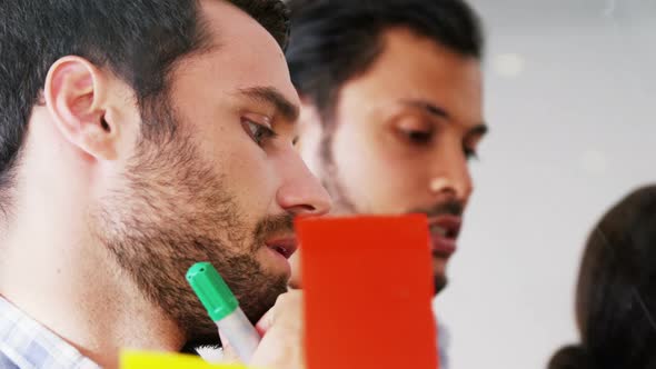 Businesspeople interacting over sticky notes