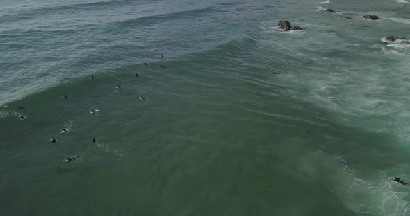 Aerial drone view of Guincho beach with some waves crashing in Cascais Portugal. Bodyboard time.