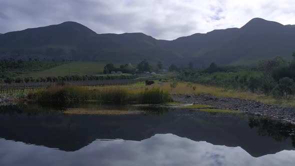 Reflection of mountains on surface of farm dam, panning shot.