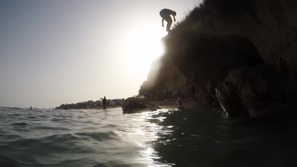 Boy Jumping from a Rock in the Beach