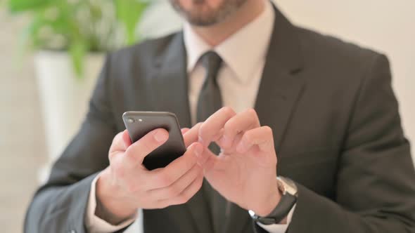 Close Up of Middle Aged Businessman Typing on Smartphone Mobile