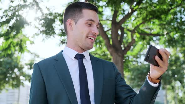 Businessman using smartphone in park