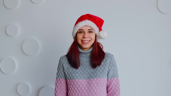 Young Woman in Santa Hat on Background of White Patterned Wall