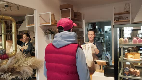 Cheerful Woman Selling Baked Goods to Client