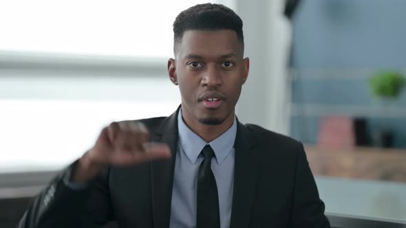 Portrait of African Businessman showing Thumbs Down Gesture