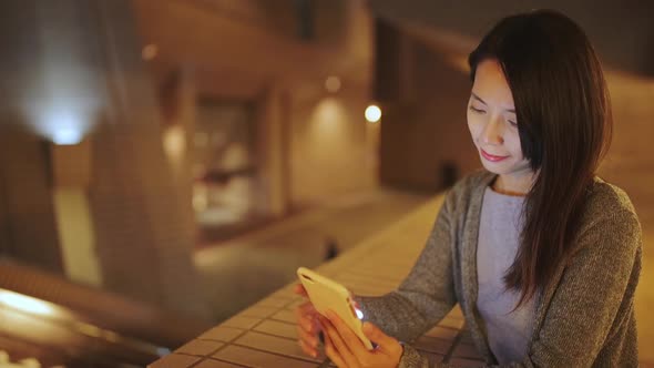 Woman text message on cellphone at evening in Hong Kong 