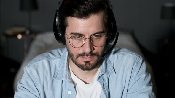 Close-up of a Young Man Thinking Looking at a Computer, Using a Laptop Working Online