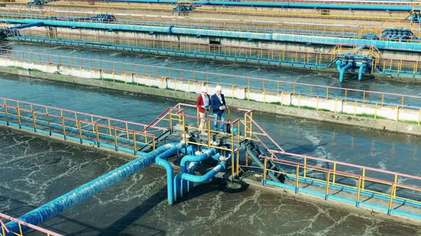 Two Businessmen Talking on the Bridge at a Cleaning Facility