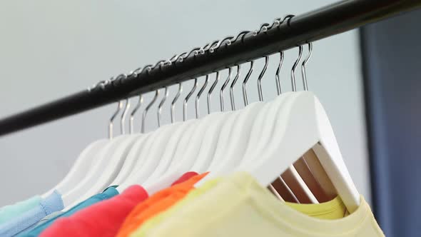 Various t-shirts arranged in a row on cloth rack 4k