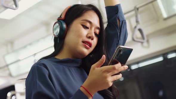 Young Woman Using Mobile Phone on Public Train