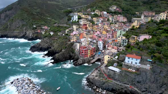 Mediterranean coastline in Riomaggiore Italy Cinque Terre harbor with crashing waves
