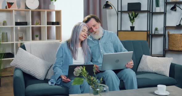 Senior Couple Sitting on the Comfortable Sofa in Cozy Living-Room with Bowed Heads to One another