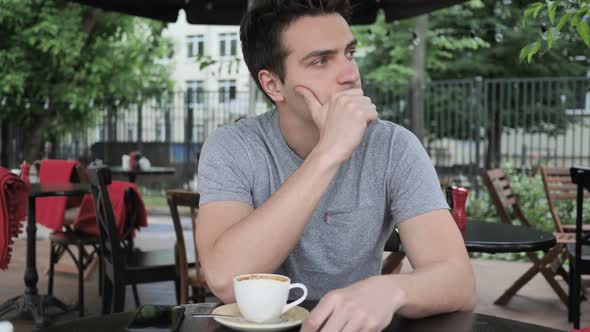 Thinking Pensive Young Man Sitting in Cafe Terrace