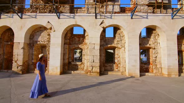 A young girl in a blue dress at the old building