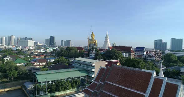 Big Golden Buddha sitting in a city landscape, Wat Paknam under construction. DRONE AERIAL