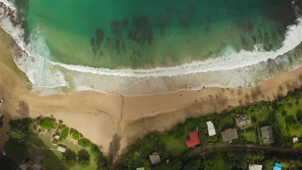 Haena. Hawaii. Ocean Surf Washing Sandy Shore with Houses Standing Close To the Beach.