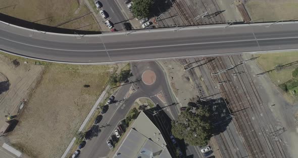 Black car driving through round about as seen from static aerial perspective.