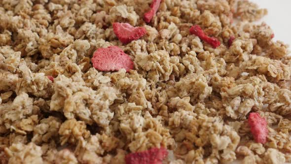 Tilting over dehydrated  crunchy cereals close-up 4K 2160p 30fps UltraHD footage - Dried strawberrie