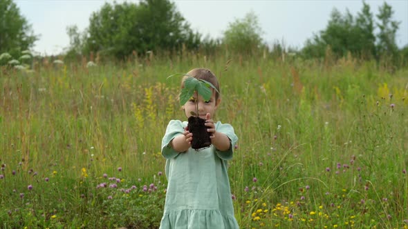 Little Girl Holding an Oak Tree Sprout in Her Hands