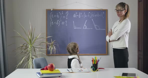 Cute Caucasian Schoolgirl Looking Back at Blackboard