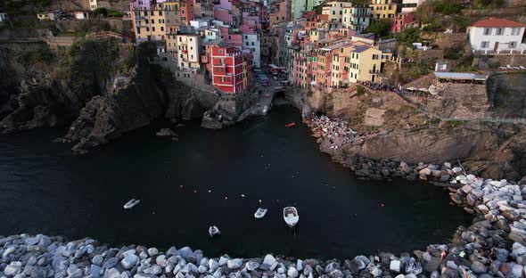 Charming village of Riomaggiore nestled on terraced hillside; aerial reveal