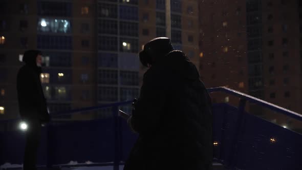 Man in Coat and Hat Goes Upstairs on City Street in Winter