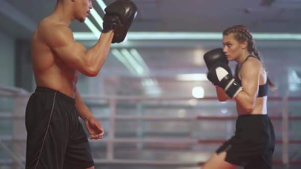 Cinematic Shoot of Boxing in the Ring, Woman Fighter Trains Punches, Punching Focus Mitts, Training