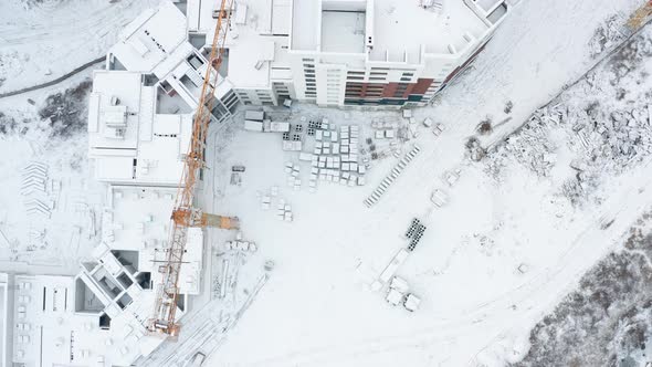 Crane at construction site covered with snow, Aerial drone view