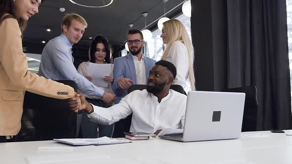 Multiracial Work Team Thanking Each Other for Fruitful Collaboration Under their Computer Project