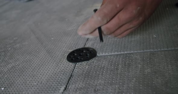 the Worker Fixes Elements of a Heat-insulated Floor By Clamps, Close Up.