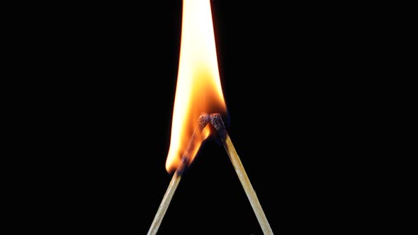 Two Matches in the Shape of the Letter L Are Lit and Burn on a Black Background