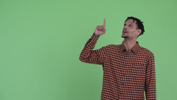 Happy Young Handsome African Man Talking While Pointing Up