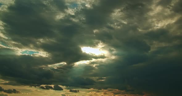 The Sunbeams Break Through Dense Gray Cumulus Moving Clouds Time Lapse