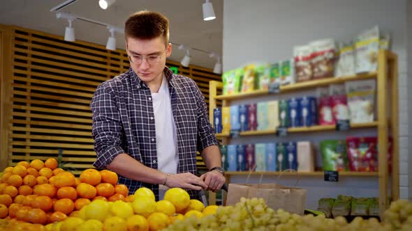 Man Buying Citrus Fruit at Healthy Food Store