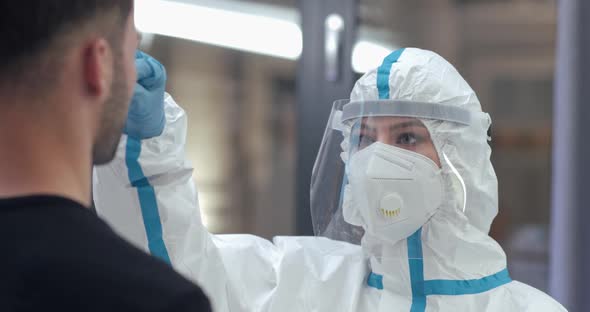 Female Doctor Wear Chemical Protection Takes a PCR Swab From a Man Test for the Presence of