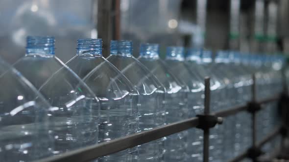 Empty plastic bottles with a volume of 5 liters move along the conveyor