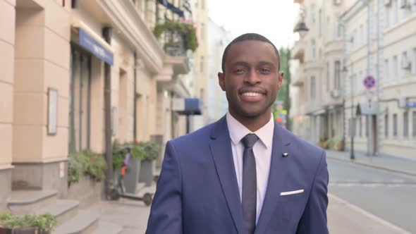 Close Up of Smiling African Businessman Walking on the Street