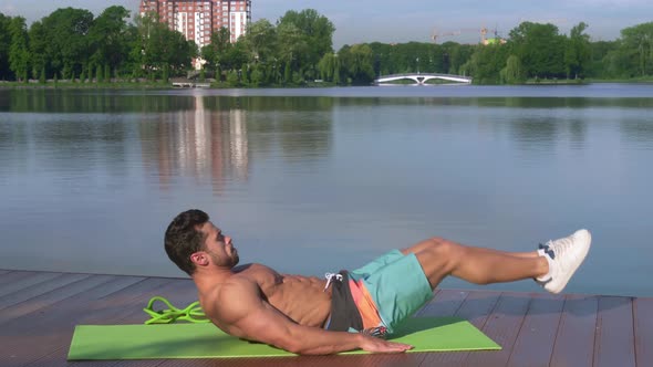 Topless Man Doing Lower Abs Exercise By Lifting Legs Up