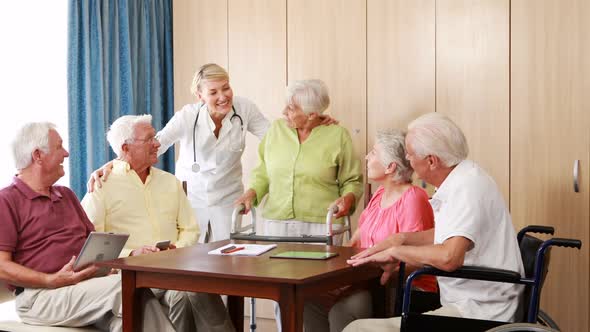 Female doctor interacting with senior citizens