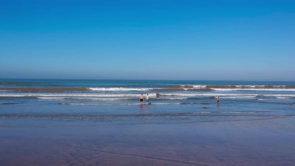 Drone Shot of people walking into the sea