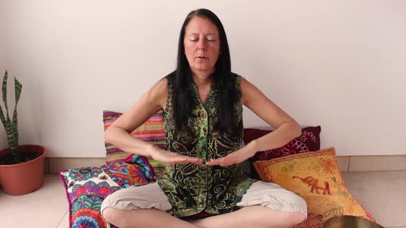 Middle age woman doing respiratory exercises, inhaling and exhaling. Concept of zen aura and relax.