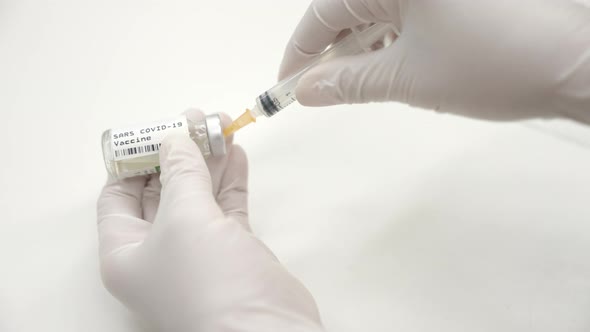 close up of drawing covid 19 vaccine from a vial into a syringe