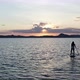 A Young Woman is Rowing an Oar Standing on a Board in the Lake at Sunset - VideoHive Item for Sale